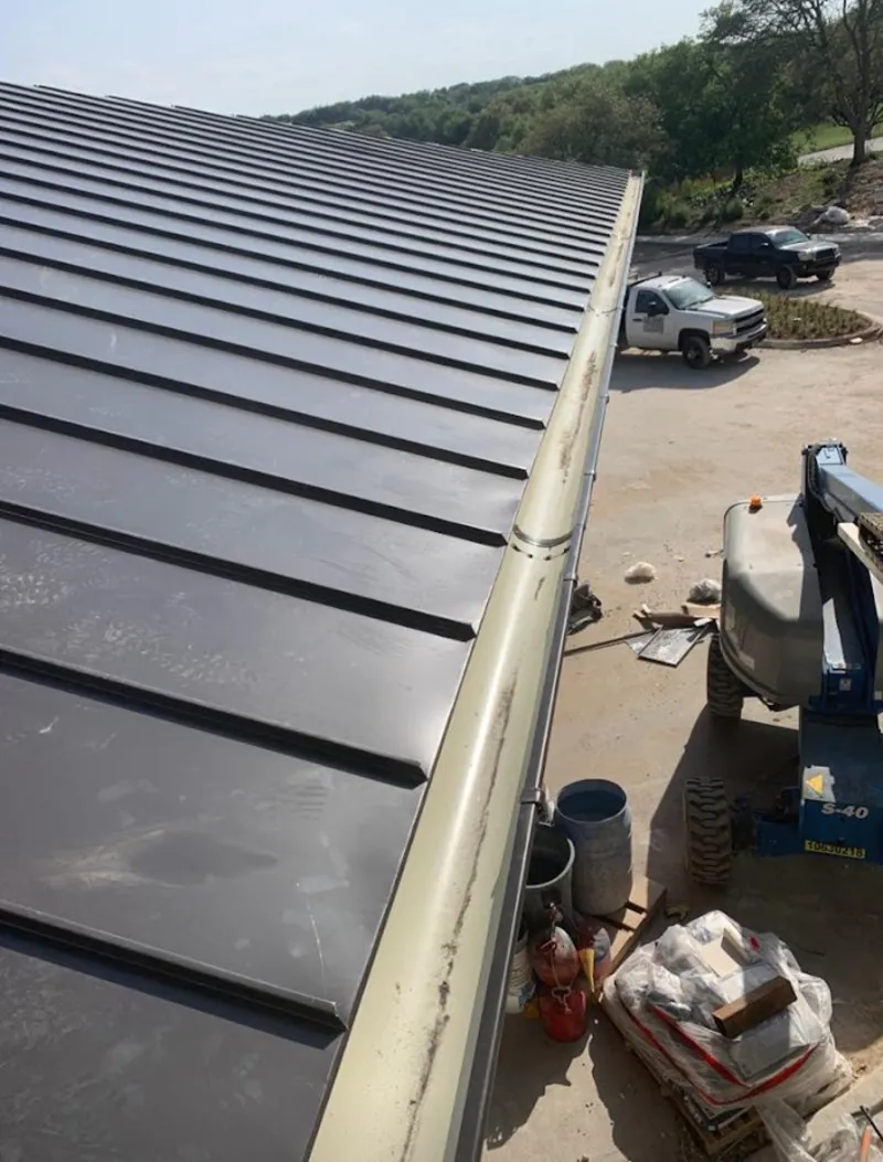 Standing seam panel and gutter detail on a metal roofing jobsite in Barstow